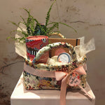 Load image into Gallery viewer, "Protect" Hamper in floral fabric storage basket with a plant